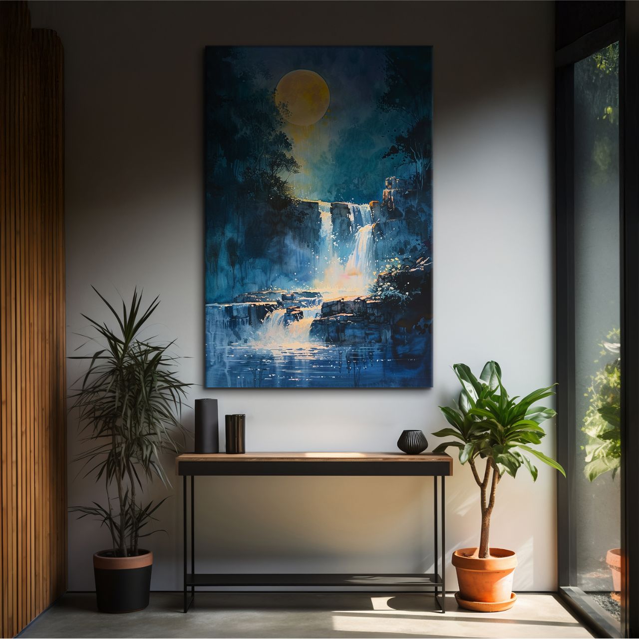 Framed artwork of a waterfall scene with a moon above, displayed on a wall in a room with plants and a console table.